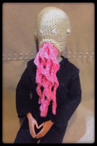 A Barbie doll wrarinf an Ood mask and outfit. 